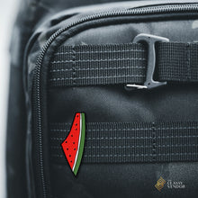 Load image into Gallery viewer, Palestine Watermelon Enamel Pin pinned on a black backpack. Sold by the Classy Vendor.
