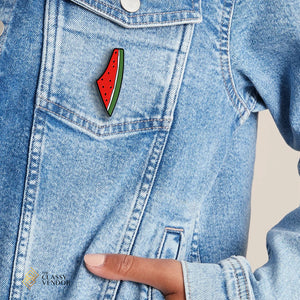 Palestine Watermelon Enamel Pin on a blue jean jacket worn by a female model. Sold by the Classy Vendor.
